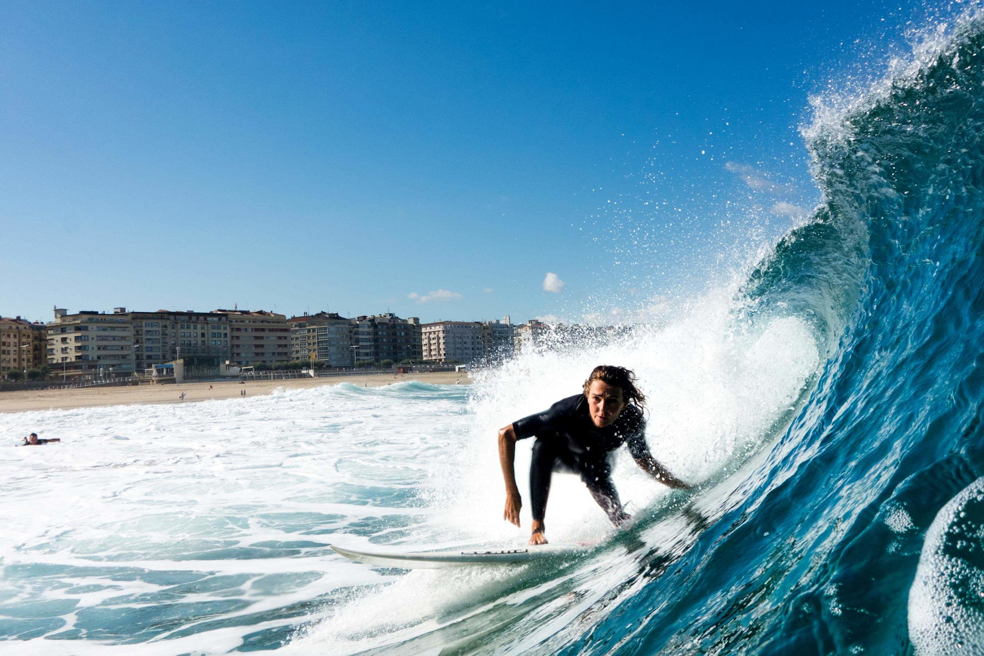 Surfer riding the waves at Zurriola beach © @donostiaturismoa