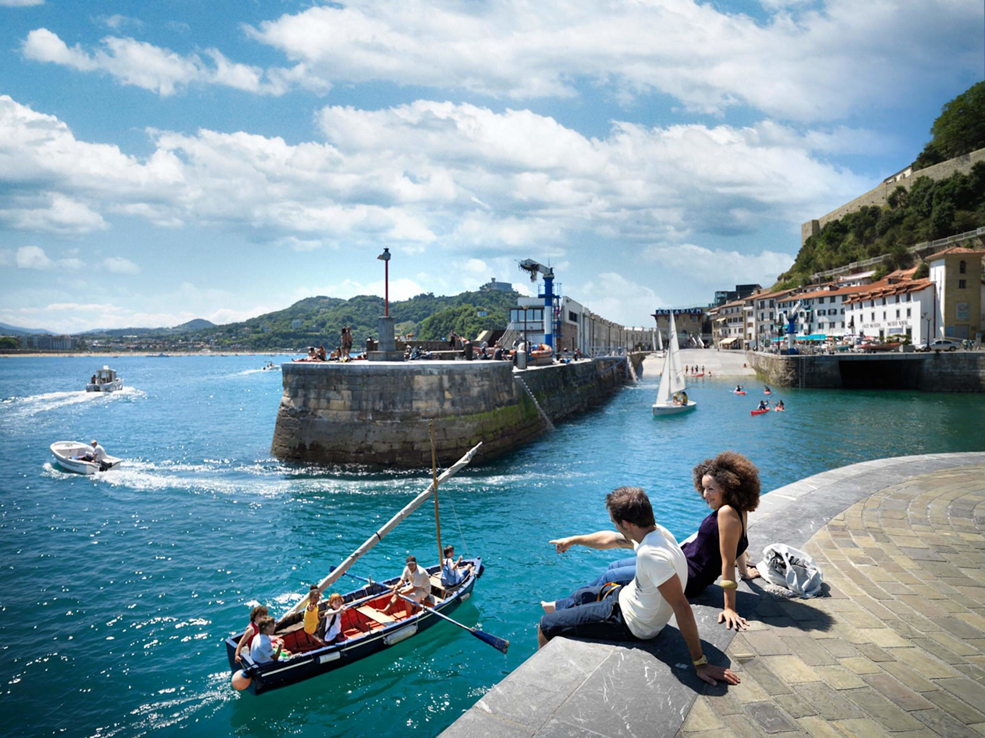 Couple sitting on the harbour walls in San Sebastián enjoying the view © @donostiaturismoa