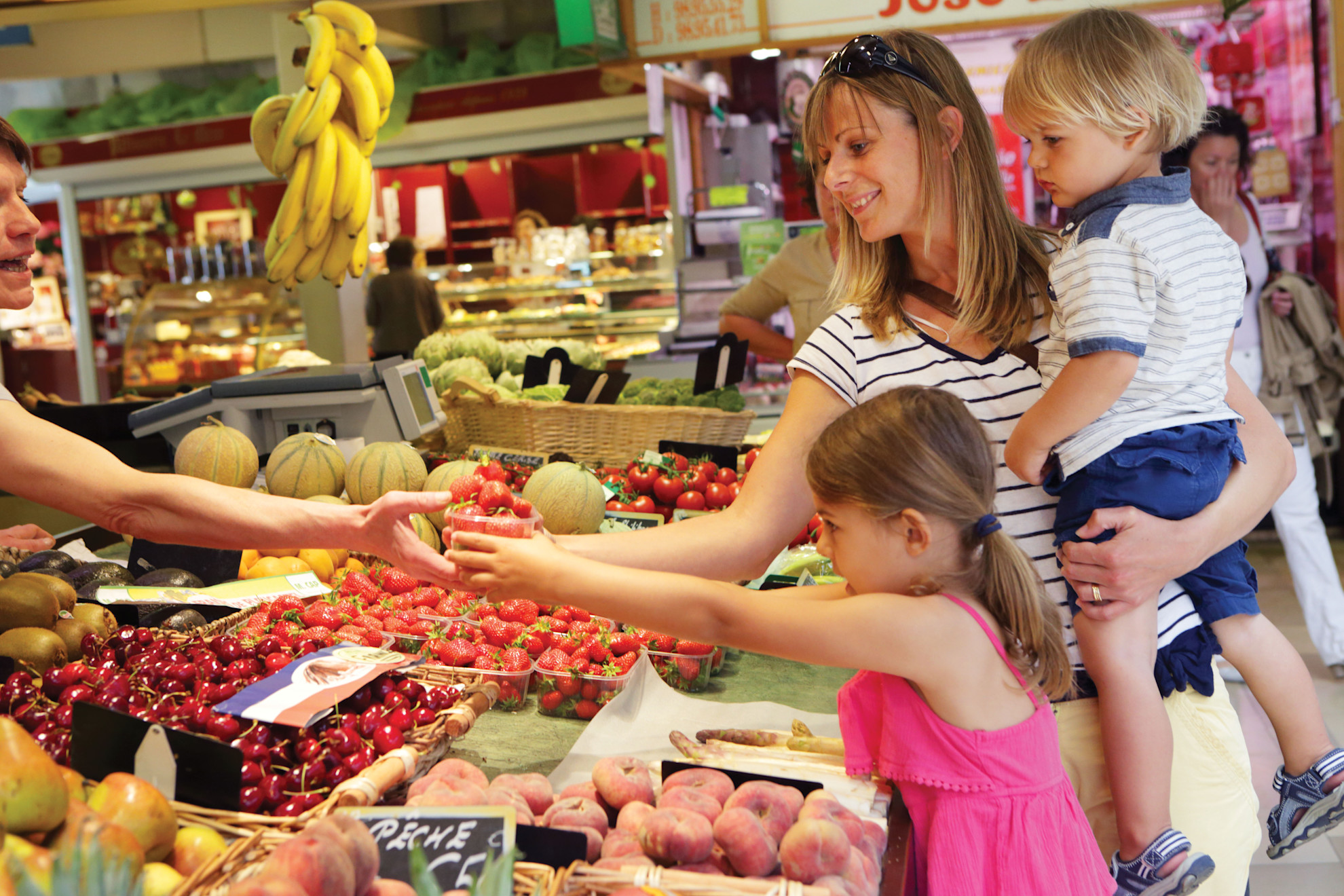 A family buying fruit in a market