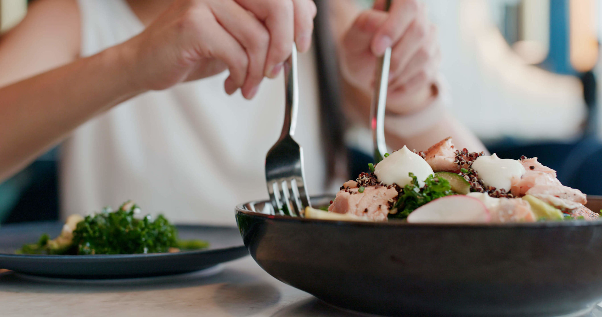 Woman enjoys fish salad in restaurant