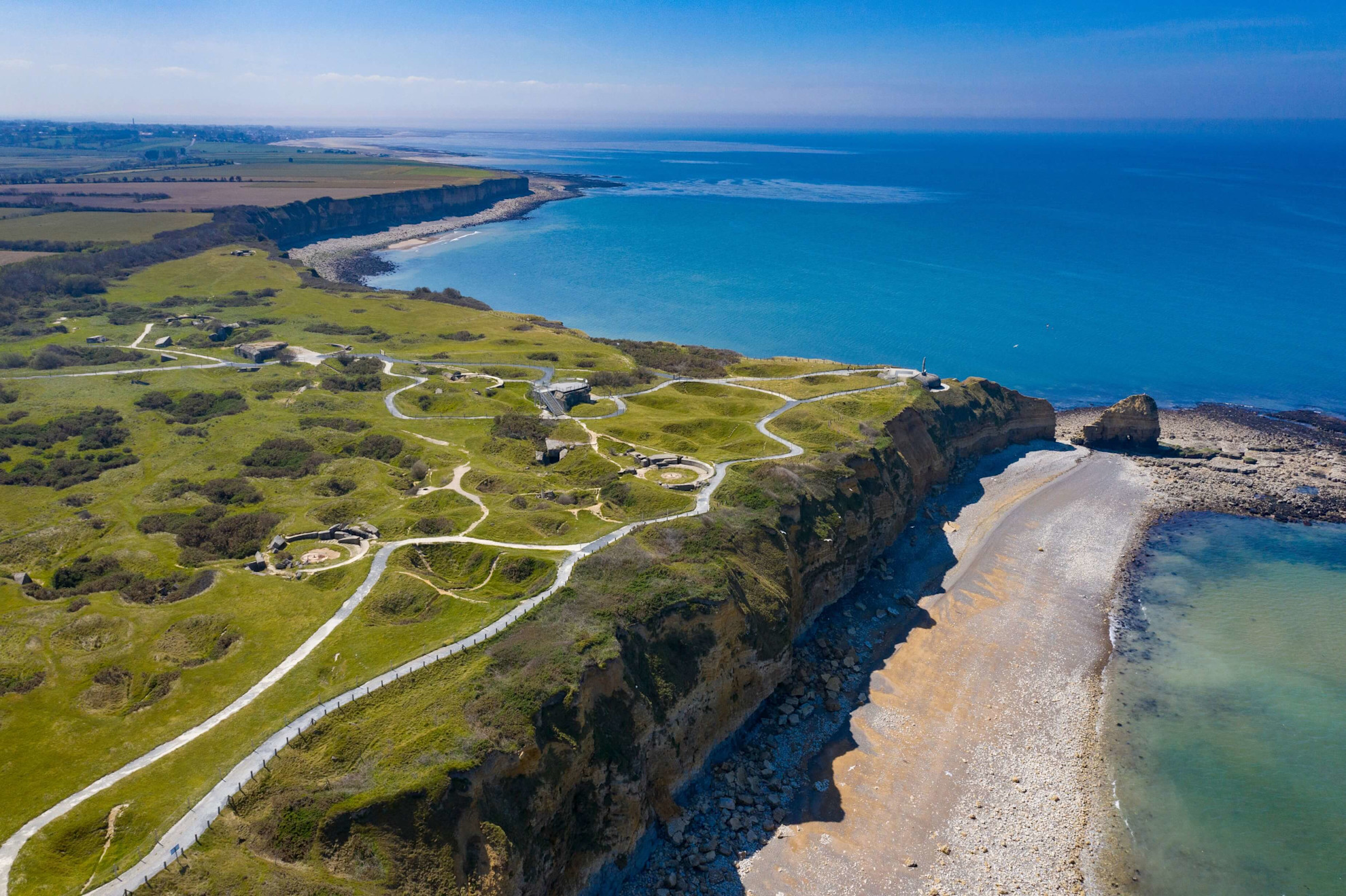 Aerial view of Pointe du Hoc still covered in fortifications and bomb craters