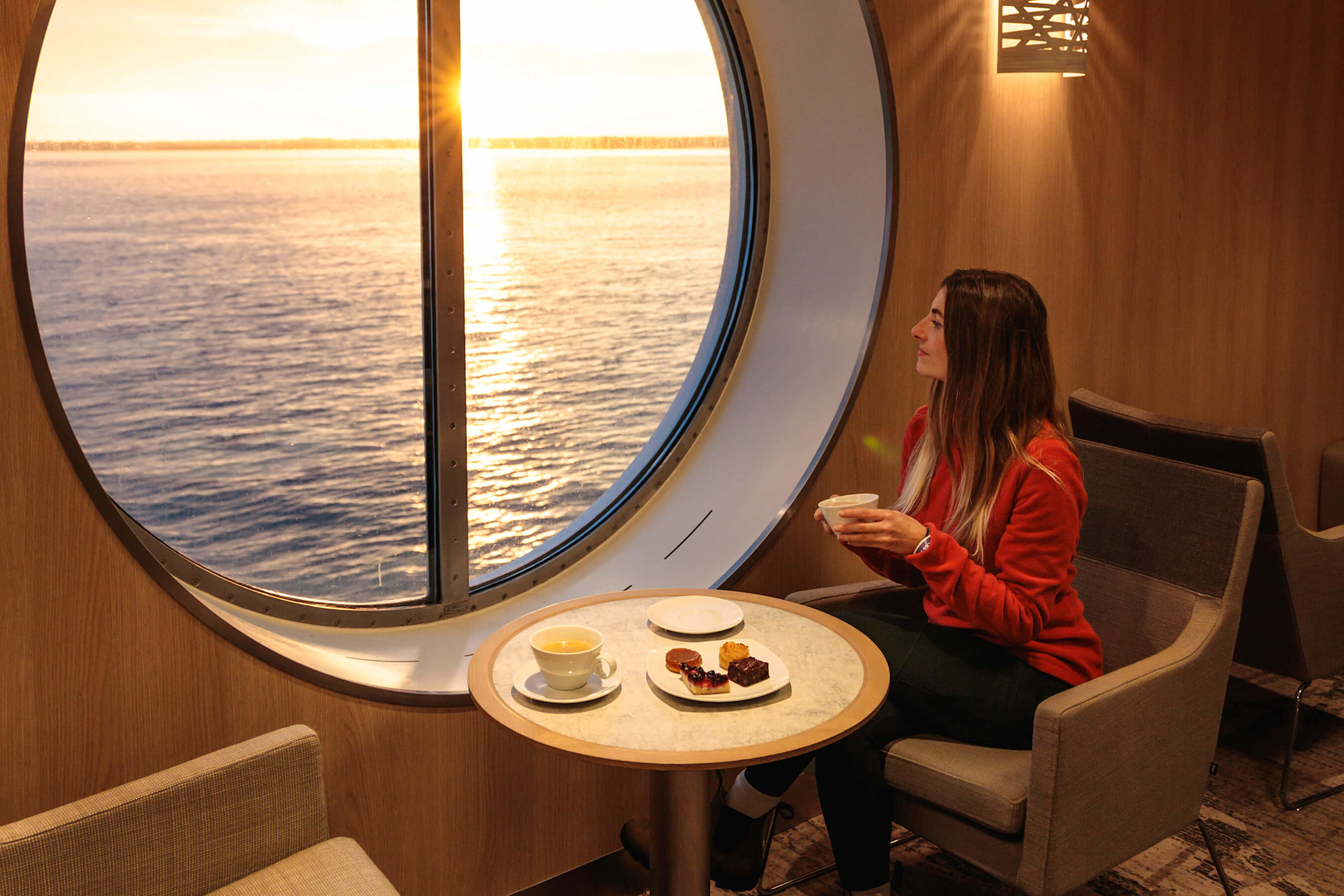 Woman sitting beside the window on Salamanca enjoying tea and cake