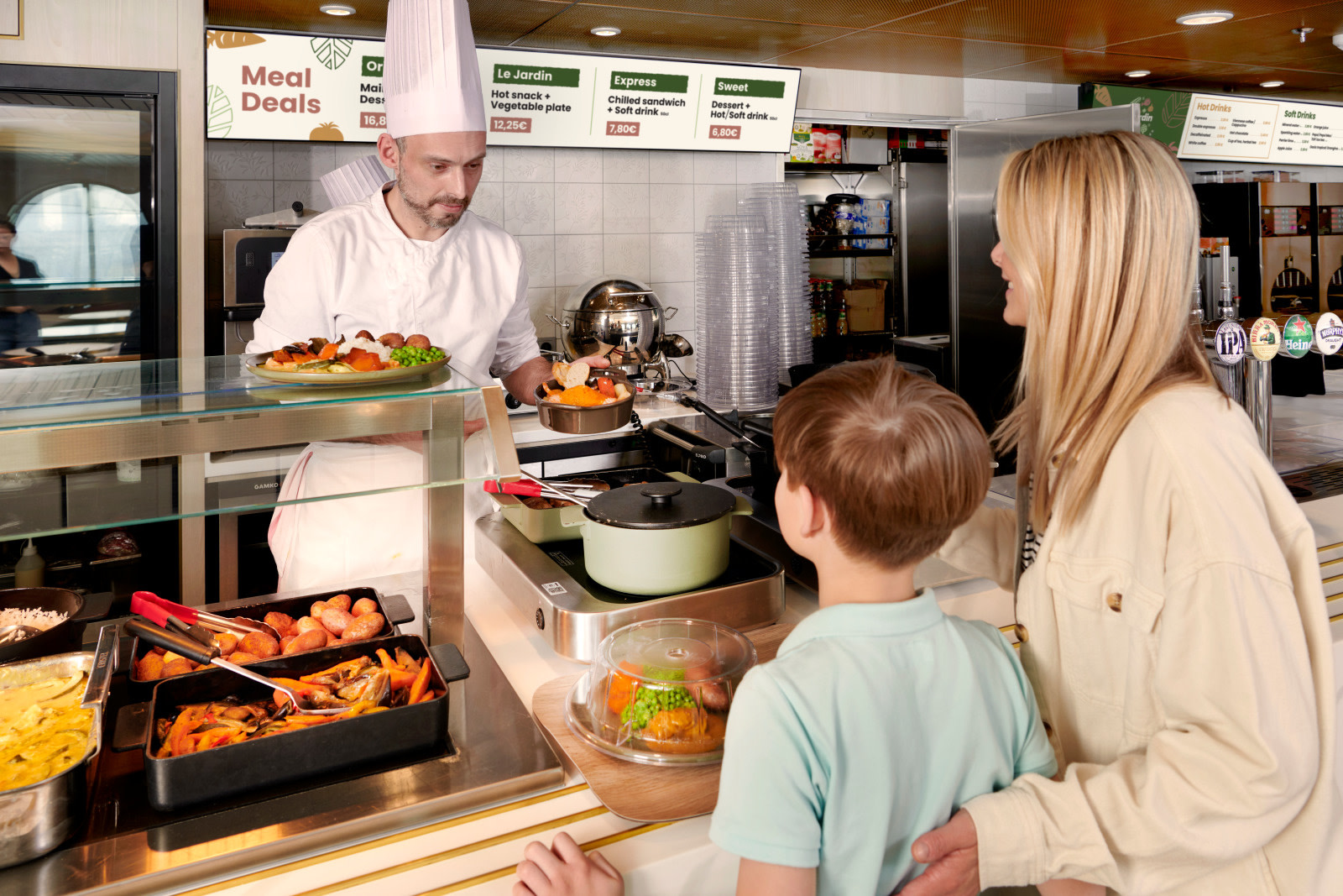 A cook serves a dish to a woman and a child