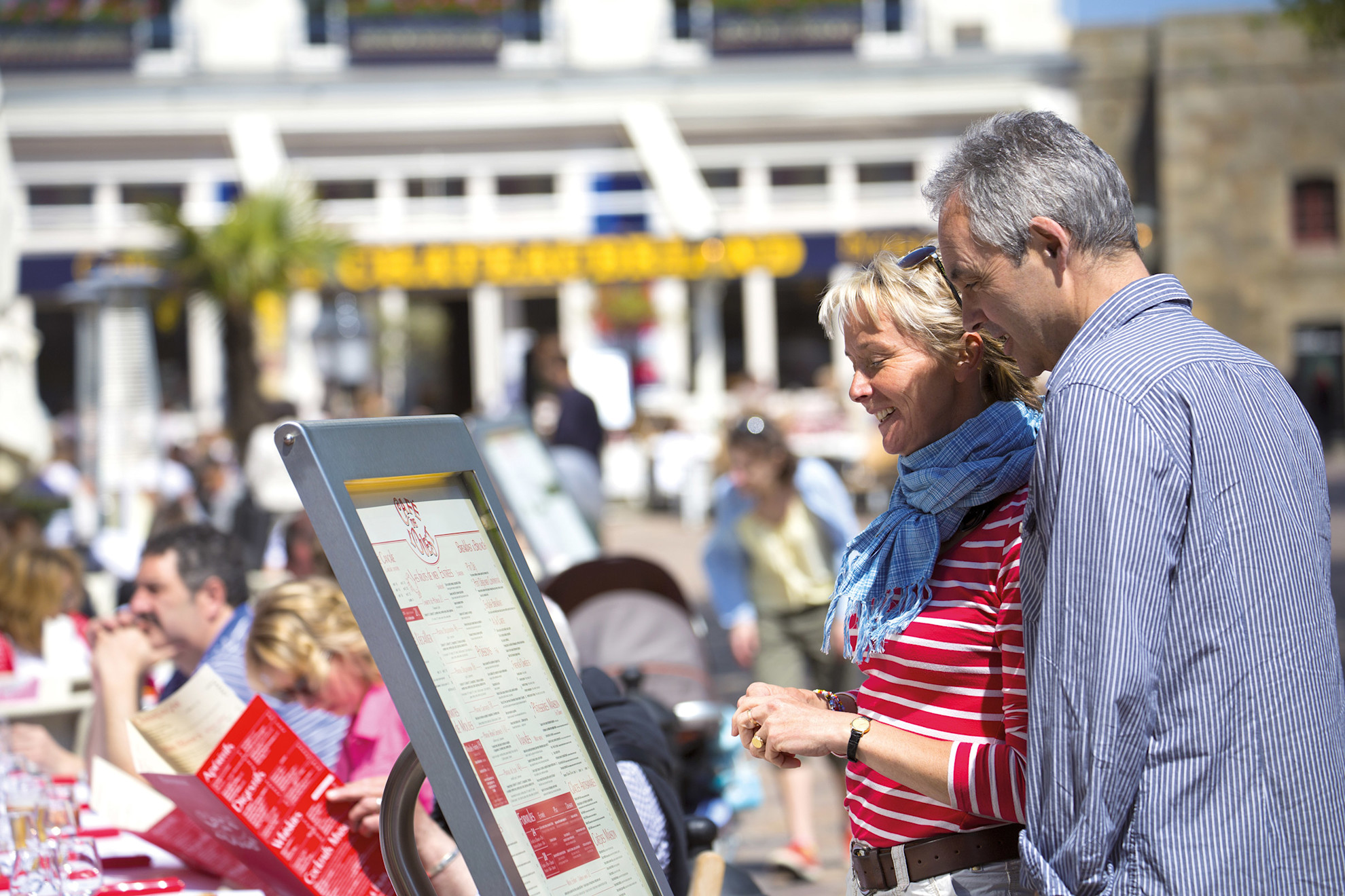 Couple looking at the menu of Cafe de L'Ouest, St Malo