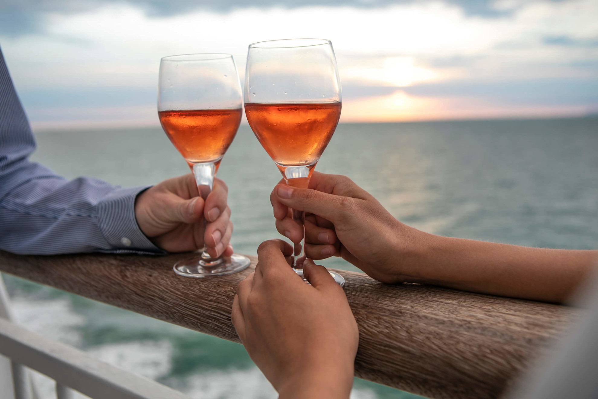 Couple with wine glasses on deck  