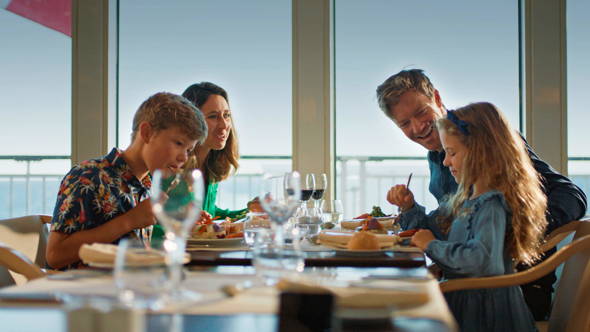 Family dining on board with sea views in the background