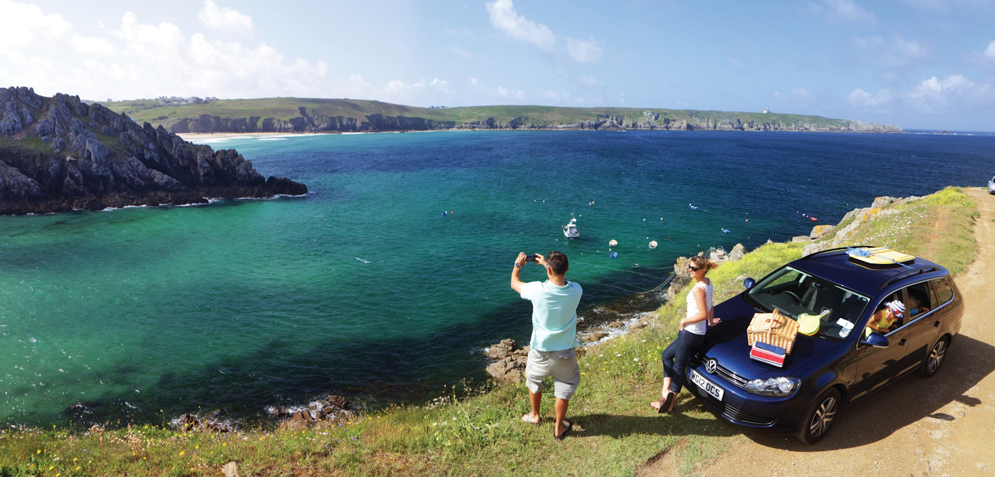 Family with car parked looking across the Baie des Trépassés in Brittany