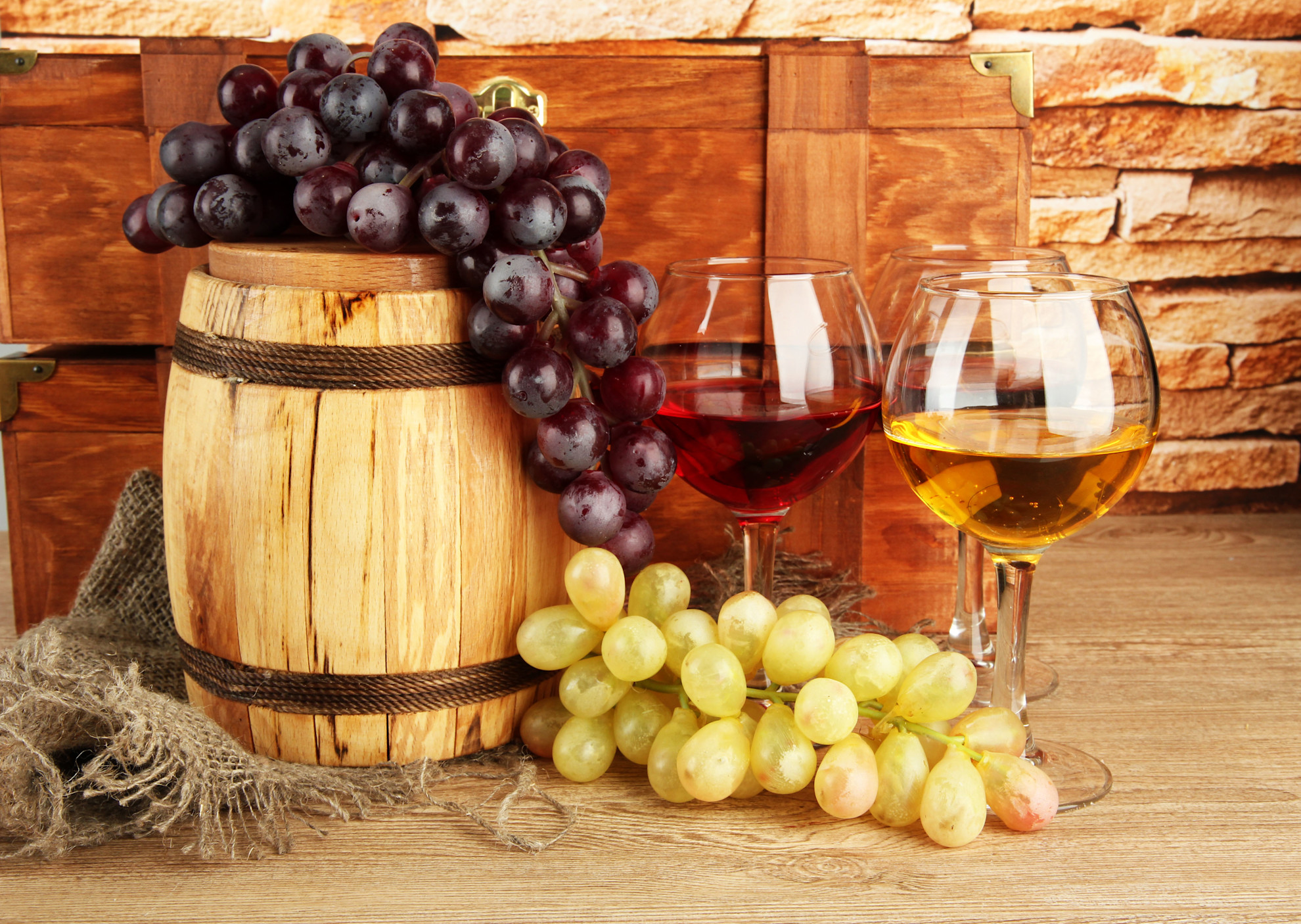 Grapes and wine glasses in front of wine barrel © Shutterstock