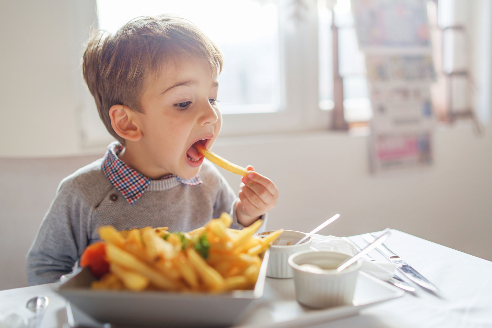 A young boy eating at a table