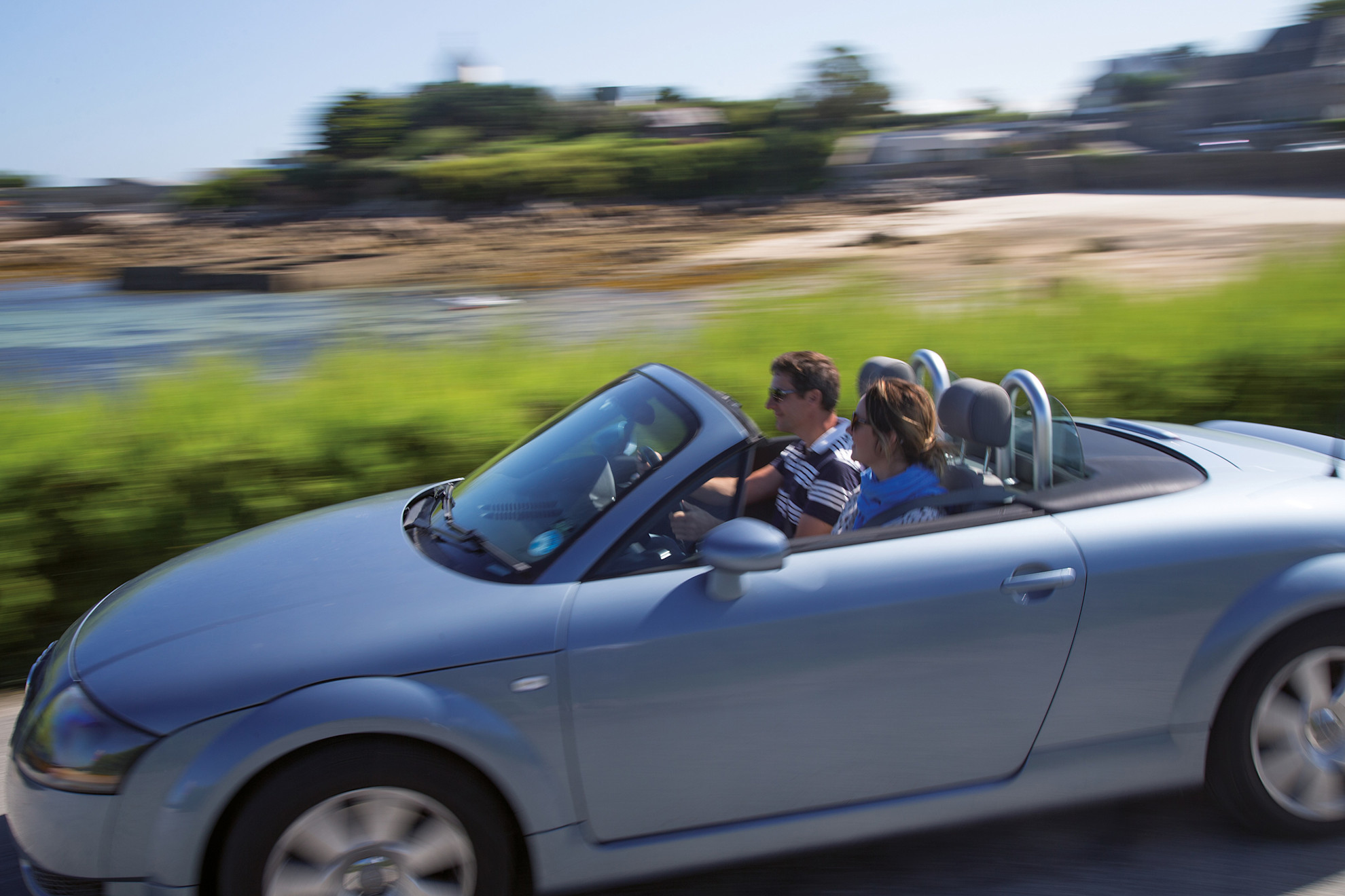 A man and a woman reading by their car