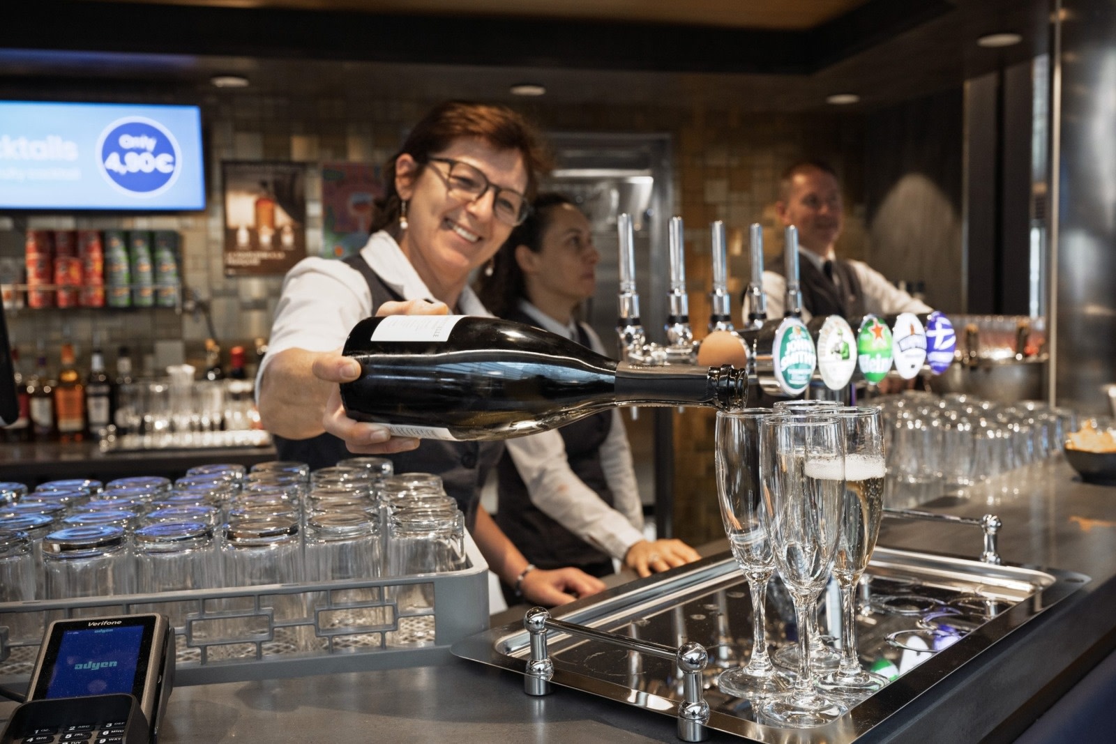 Waitress serving a drink behind a counter 